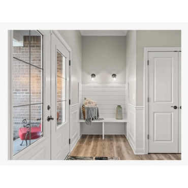 Cozy entryway with white bench, soft lighting, and decorative pillows.