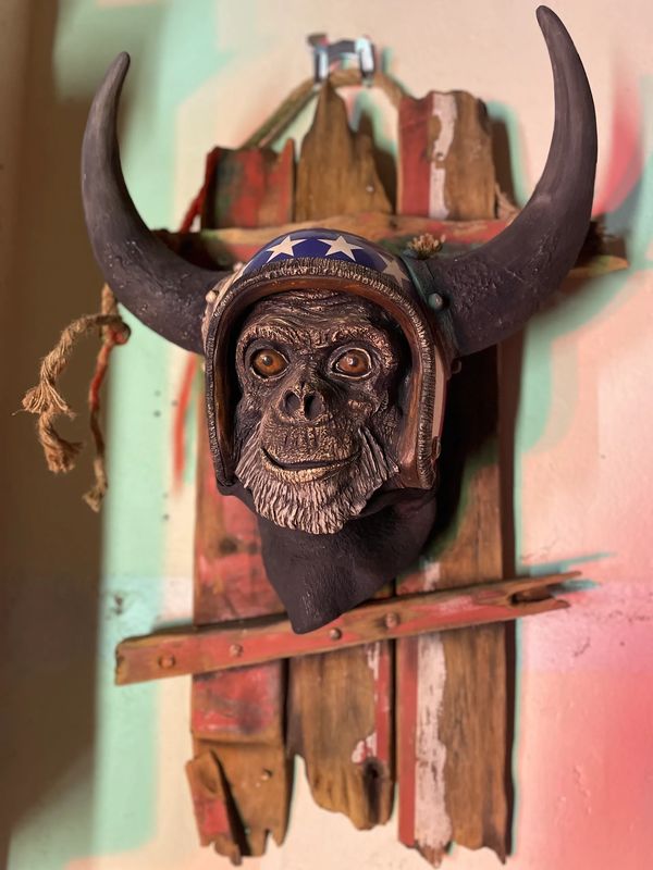 Mounted sculpture of a monkey wearing a star-spangled helmet with large horns.