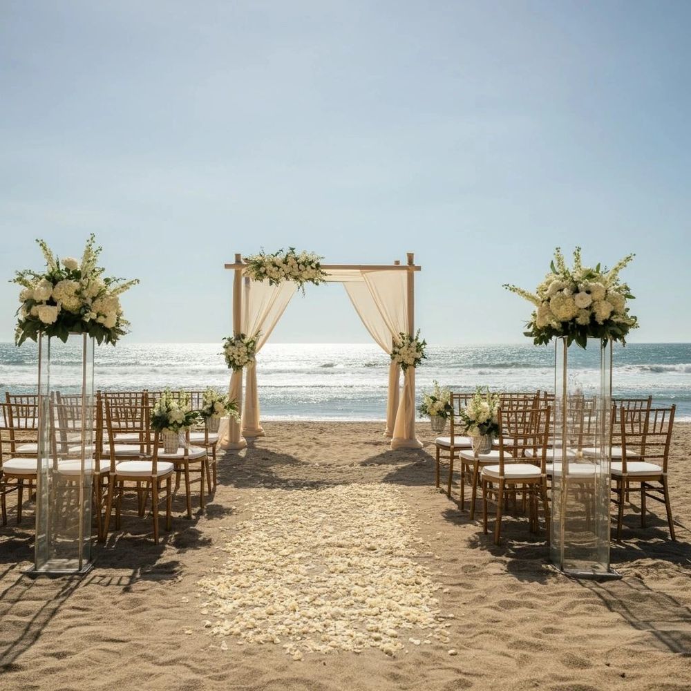 Elegant beach wedding setup with floral decorations and ocean view.