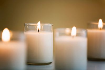 Lit white candles in glass holders creating a warm, calm ambiance.
