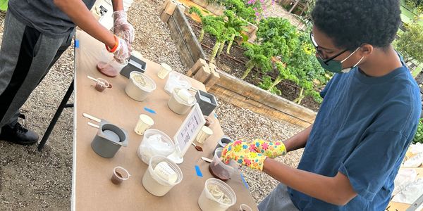 Two people preparing ingredients for a cooking or baking activity outdoors.