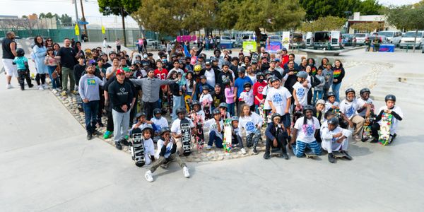 Large group of skateboarders posing at a skate park.