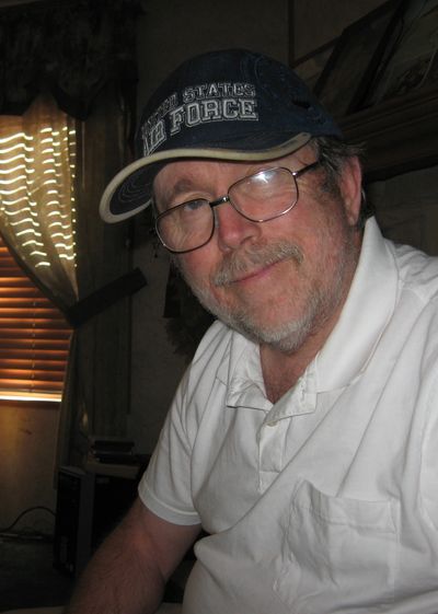 Smiling man wearing glasses and a US Air Force cap.