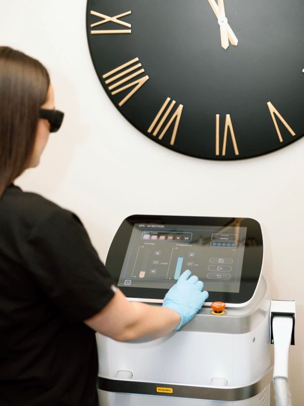 Person operating a modern touchscreen device with a large clock in the background.