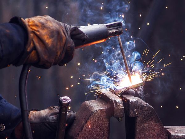 An engineer welding a piece of metal