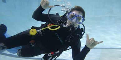 Happy Scuba student taking her PADI Open Water Refresher in the pool before leaving on a trip!