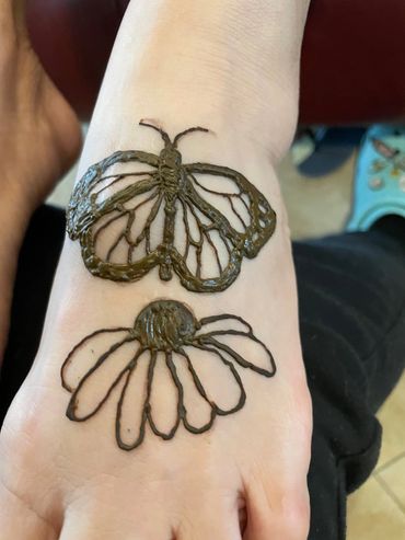 Butterfly and flower henna ink on woman's foot