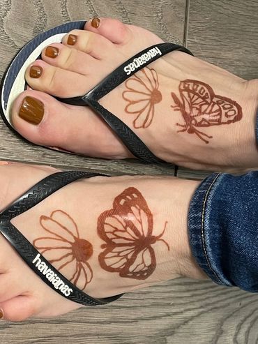 A woman's feet with butterfly and flower henna designs