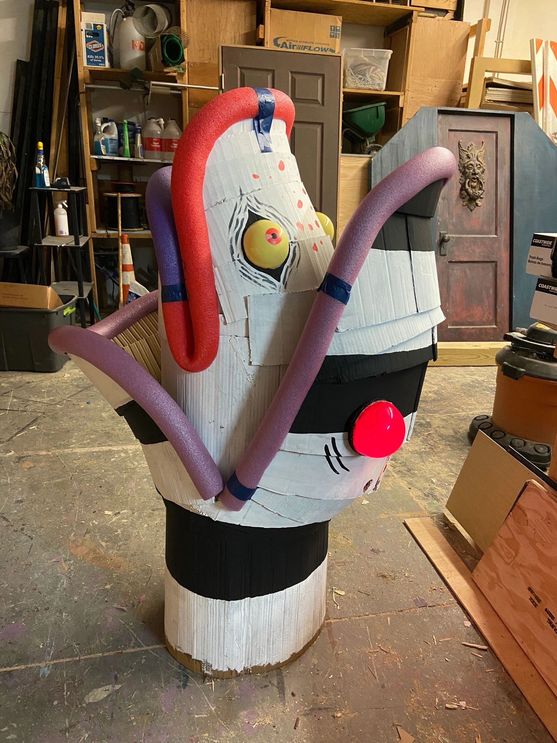 Large cardboard and foam sculpture resembling an animated character.