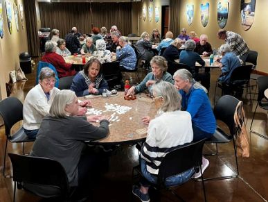 Seniors playing a game together in a community room.