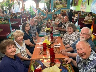 A large group of people enjoying a meal together at a restaurant.