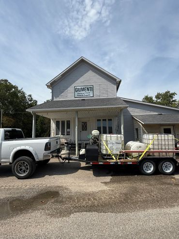 Pickup truck with trailer parked in front of Giumenti General Store.