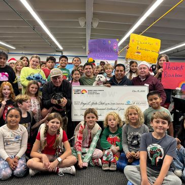 Sparky and kids from the boys & girls club with the big donation check