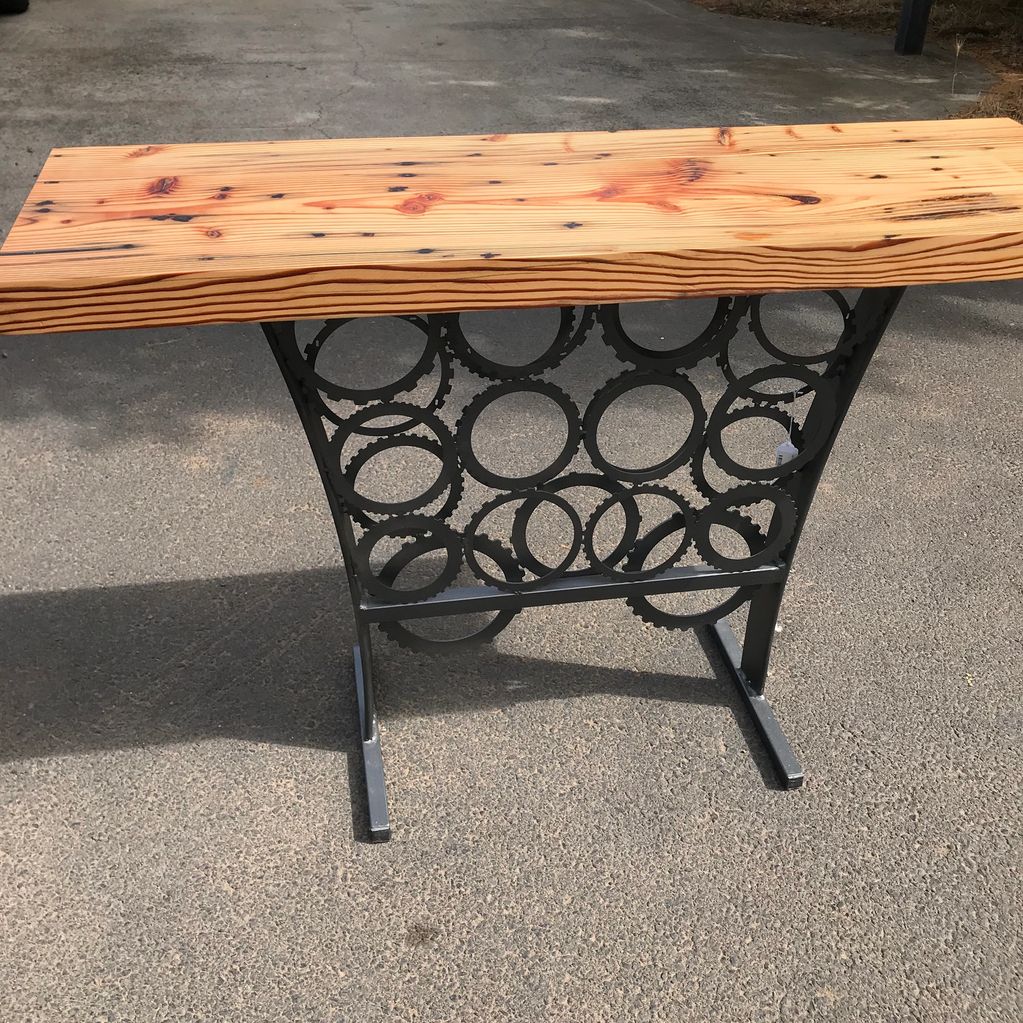 Wooden tabletop with unique metal base made from circular gears.