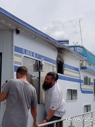 Two men working on a boat near the entrance.