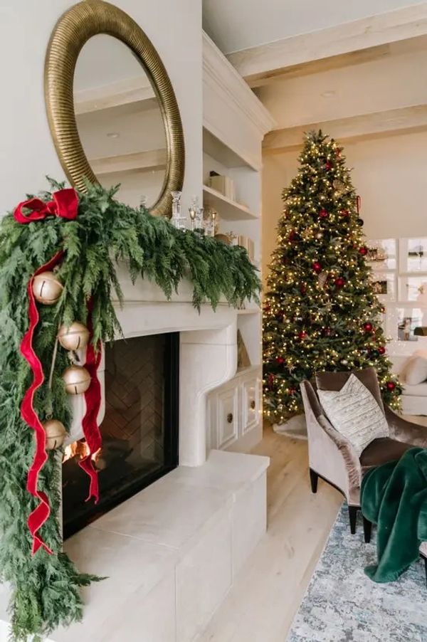 Cozy living room decorated for Christmas with a tree and fireplace garland.
