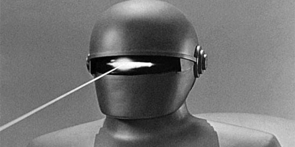 Black and white image of a robot firing a laser beam from its eye slit.