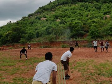 Guest in action, playing cricket at the spacious grounds of Namooru Ecostay.