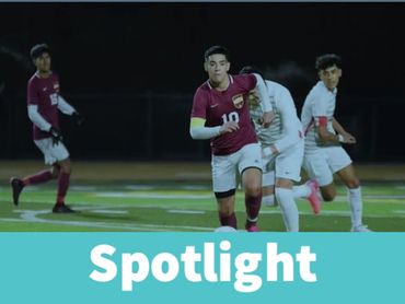 High school soccer players in action at night.