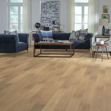 Modern living room with light wood flooring and navy blue furniture.