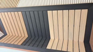 Geometric wooden bench with alternating light and dark planks.