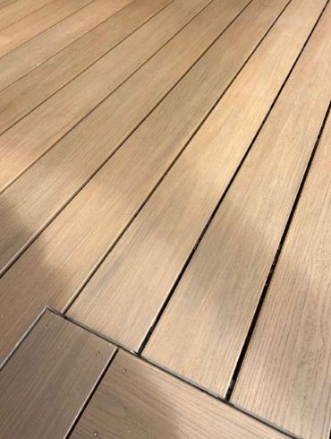 Close-up of wooden deck planks with visible grain and gaps.