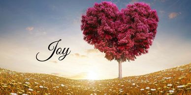 Heart-shaped pink tree in a field with the word 'Joy'.