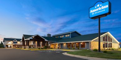 Exterior view of an AmericInn hotel at dusk.