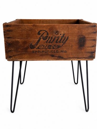 Rustic wooden planter box with metal legs and vintage lettering.
