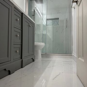 Modern bathroom with glass shower and gray vanity.