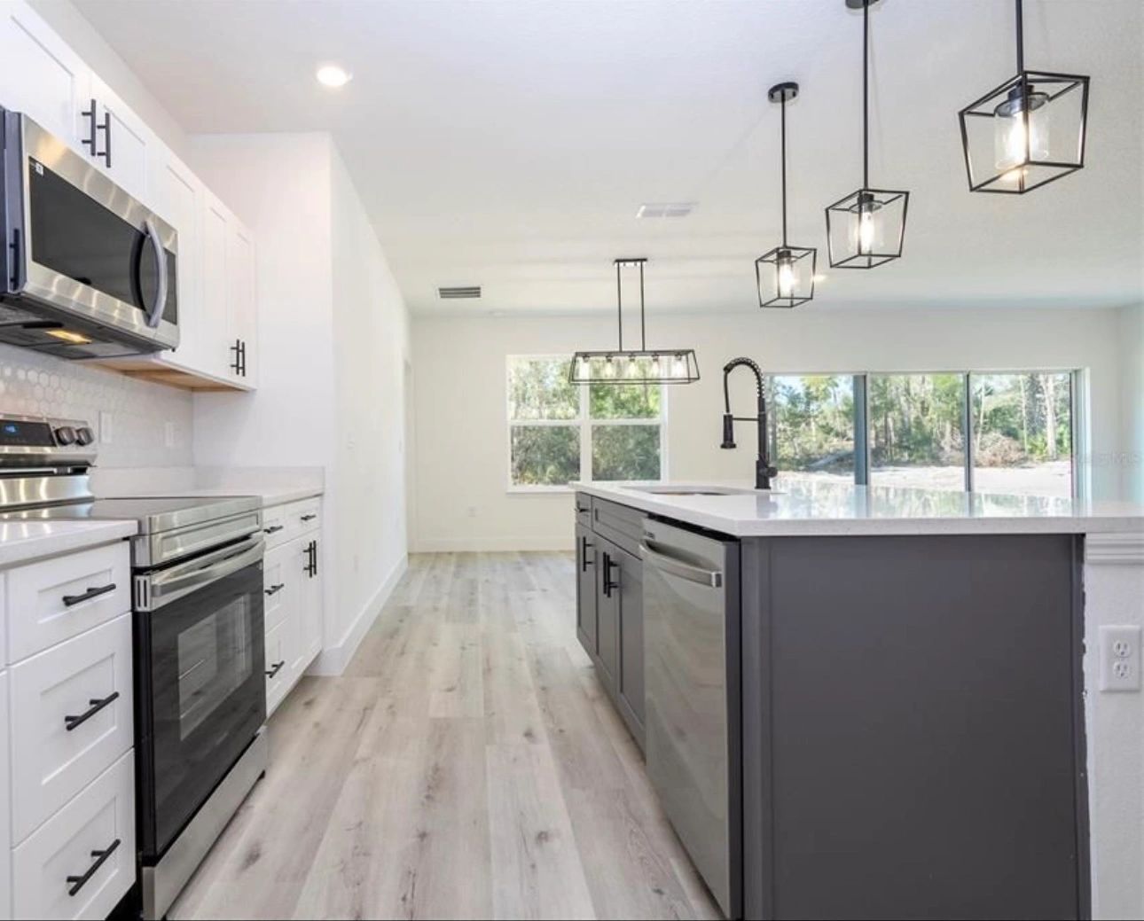 Modern kitchen with stainless steel appliances and grey island.