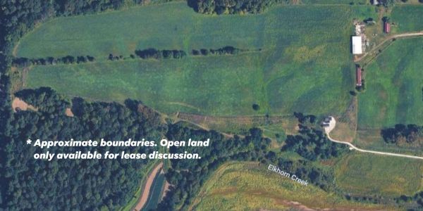 Aerial view of farmland with marked boundaries and a creek.