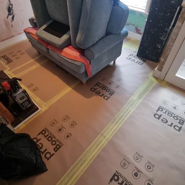 Furniture and flooring carefully protected before interior painting and decorating work.