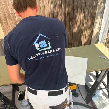 Decordreams painter in branded workwear preparing materials for a painting and decorating project.