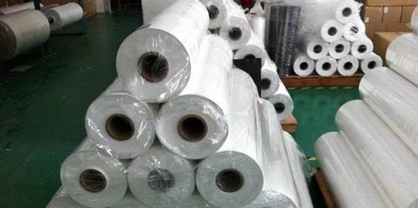 Stack of white plastic or vinyl rolls wrapped in plastic.
