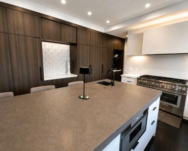 Modern kitchen with dark wood cabinets and large island.