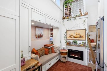 Cozy indoor seating area with built-in bench, fireplace, and autumn decor.
