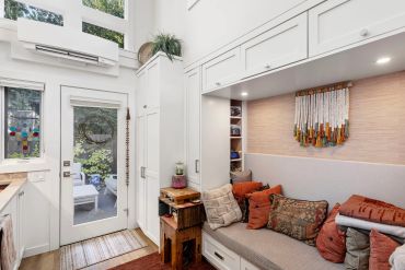 Cozy corner with white cabinets and colorful cushions.