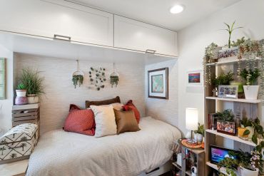 Cozy bedroom with plants and family photos.