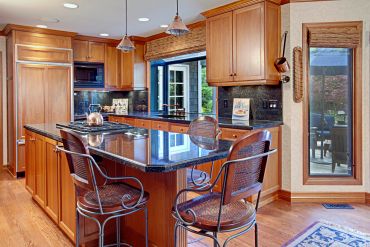 Cozy kitchen with wooden cabinets and black granite countertops.