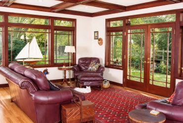 Cozy living room with burgundy leather furniture and large windows.