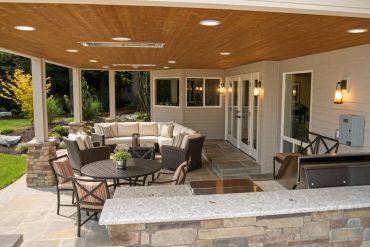 Covered patio with wicker furniture and outdoor dining area.
