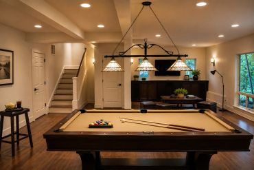 Well-lit game room with a pool table and cozy seating area.