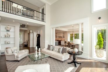Bright and spacious living room with high ceilings and neutral tones.