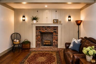 Cozy living room with brick fireplace and leather sofa.