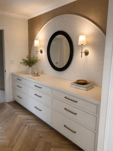 Elegant hallway dresser with mirror and wall sconces.