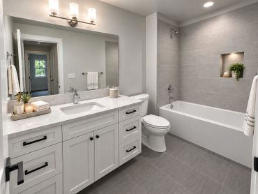 Modern bathroom with white vanity and grey tiles.