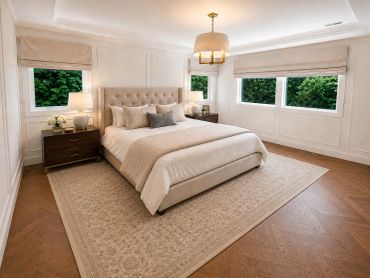 Elegant bedroom with beige tones and large windows.