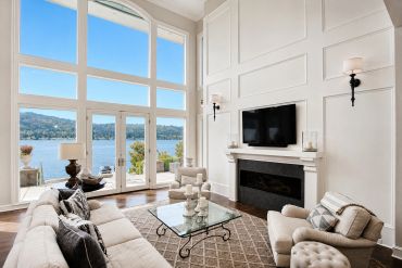 Elegant living room with large windows and lake view.