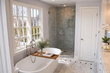 Bright bathroom with bathtub and glass shower.